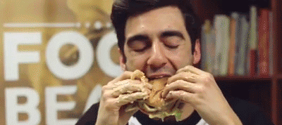 Um cara comendo um hambúrguer