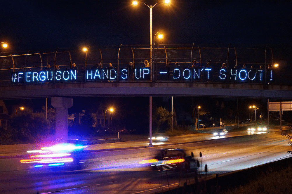 hands up don't shoot sign on bridge gif